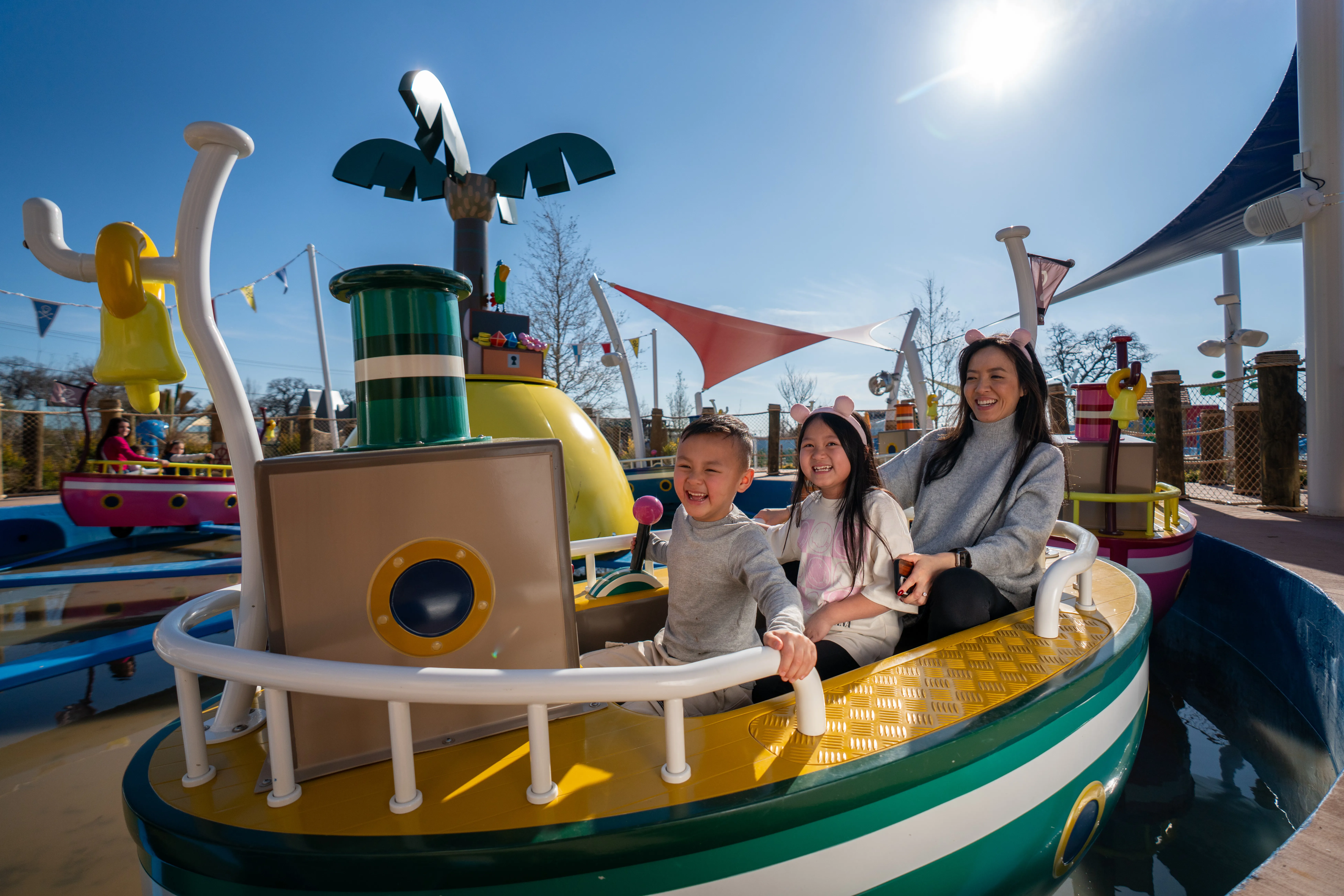 Niños y padres disfrutan del paseo Mr. Bull's High Striker en Peppa Pig Theme Park en Dallas Fort Worth. Las familias emocionadas son elevadas hacia arriba y hacia abajo en este divertido paseo, experimentando la diversión y emoción de esta atracción interactiva.